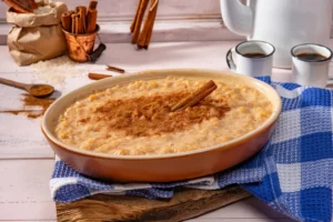 Arroz doce com canela em tigela marrom em ambiente rústico, comida tradicional brasileira.