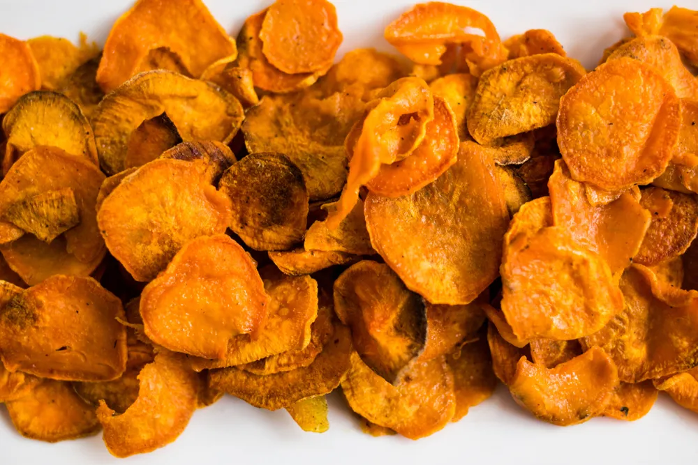 Fundo com chips de batata-doce fatiada e assada