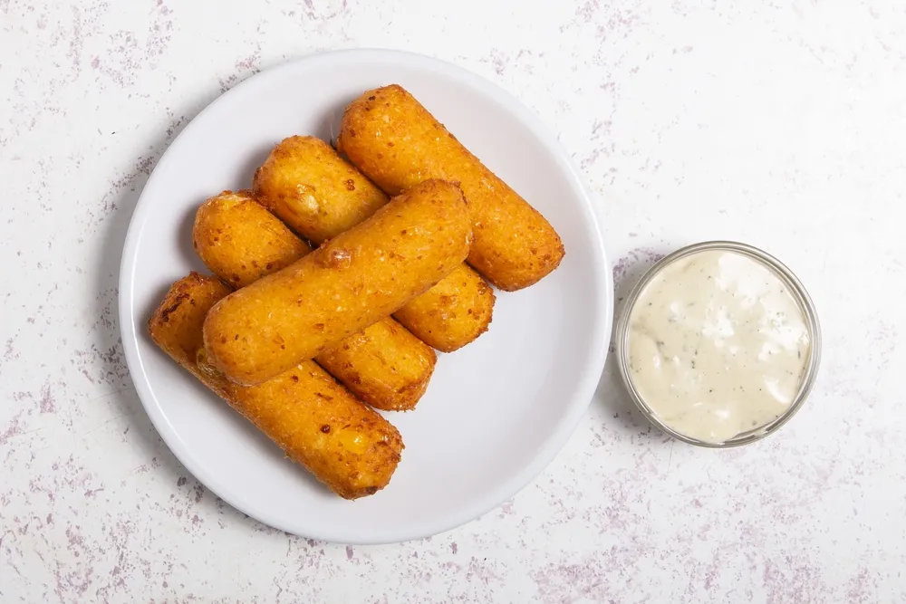 Petiscos latino-americanos chamados tequeños, feitos de massa de milho frita recheada com queijo.