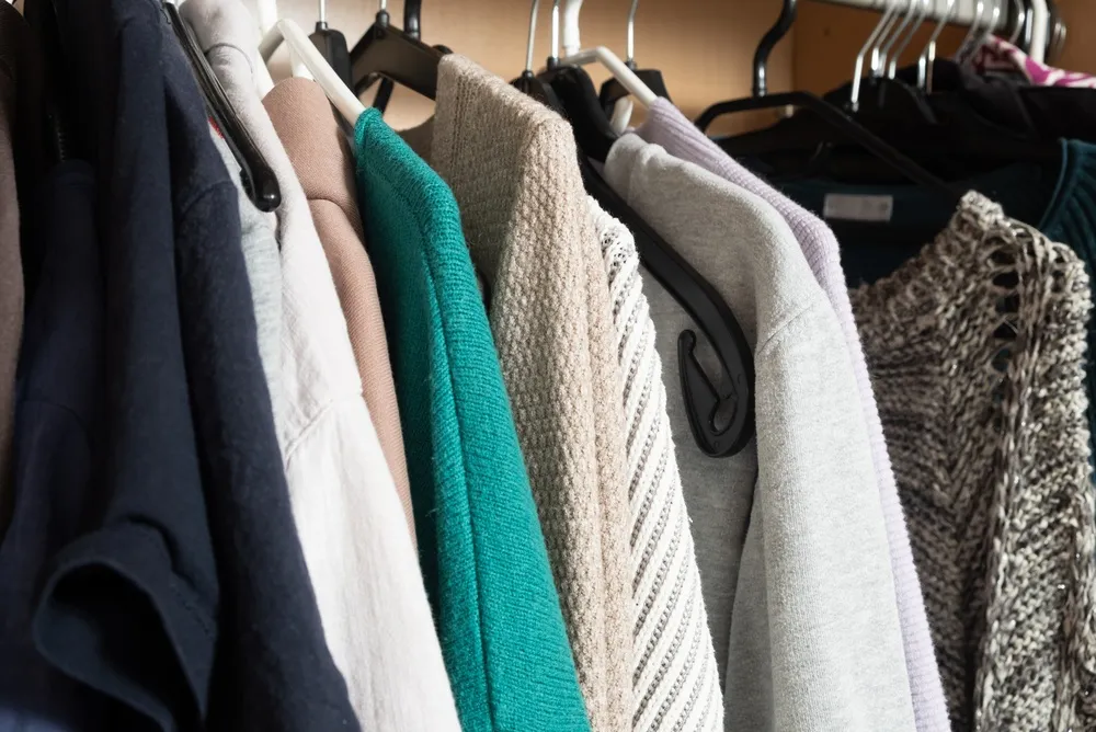 Armazenamento de guarda-roupa estético com roupas neutras e de cores suaves.