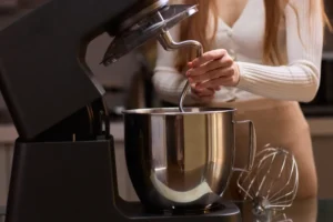 Batendo ingredientes com uma batedeira planetária em uma cozinha de estilo contemporâneo e moderno.